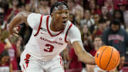 Arkansas Razorbacks guard Adou Thiero bringing the ball upcourt in an exhibition matchup with the Kansas Jayhawks.