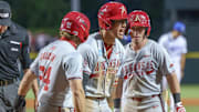 Arkansas Razorbacks Charles Davalan and Wehiwa Aloy celebrate after a homer against the Creighton Bluejays in the NCAA Regional in Fayetteville, Ark.