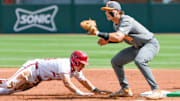 Arkansas Razorbacks left fielder Charles Davalan dives back to first against the Tennessee Volunteers in an NCAA Super Regional game in Fayetteville.