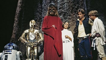(L to r) R2-D2, Anthony Daniels as C-3PO, Peter Mayhew as Chewbacca, Carrie Fisher as Princess Leia,