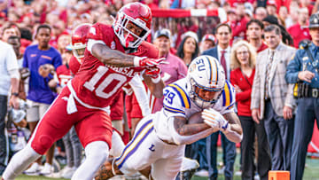 Arkansas Razorbacks linebacker Xavian Sorey tries unsuccessfully to stop LSU running back Caden Durham in a game at Razorback Stadium in Fayetteville, Ark.