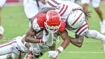 Arkansas Razorbacks running back Mike Washington is brought down a pair of Alabama A&M defenders in a game at Razorback Stadium in Fayetteville, Ark.