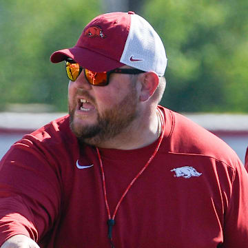 Arkansas Razorbacks offensive line coach Eric Mateos at practice working against the defensive line.