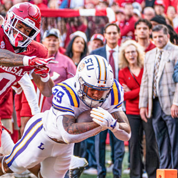 Arkansas Razorbacks linebacker Xavian Sorey tries unsuccessfully to stop LSU running back Caden Durham in a game at Razorback Stadium in Fayetteville, Ark.
