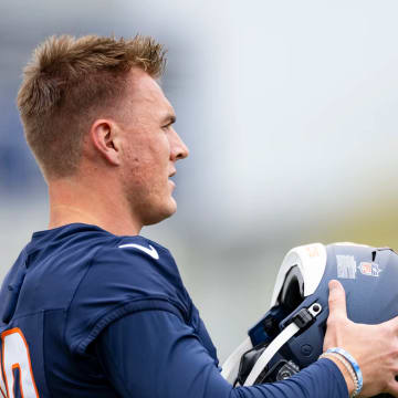 Denver Broncos rookie quarterback Bo Nix dons his helmet at rookie minicamp.