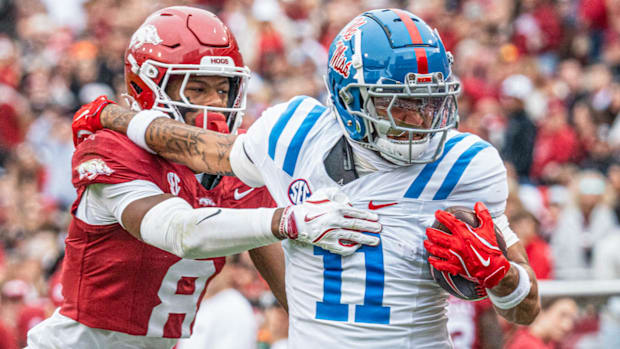 Razorbacks' defensive back Jayden Johnson struggles to get a handle on Ole Miss wide receiver Jordan Watkins