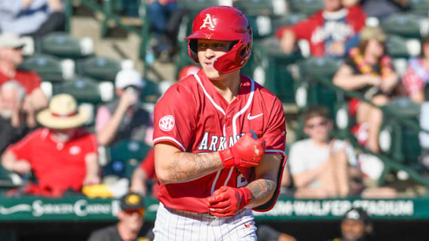 Razorbacks designated hitter Kuhio Aloy trots to first base after drawing a walk against  Grambling