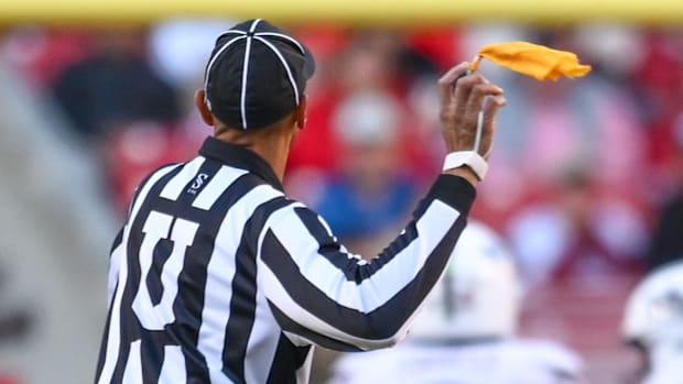 An official throws a flag in Razorback game against the Mississippi State
