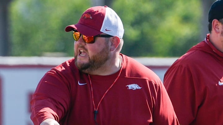 Arkansas Razorbacks offensive line coach Eric Mateos at practice working against the defensive line.