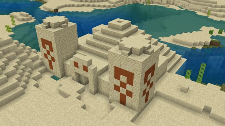 A desert pyramid next to a water.