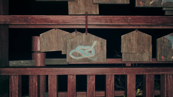 A wooden ema adorned with a picture of a snake in Silent Hill f 
