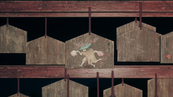 A wooden ema adorned with a three-legged kettle yokai in Silent Hill f