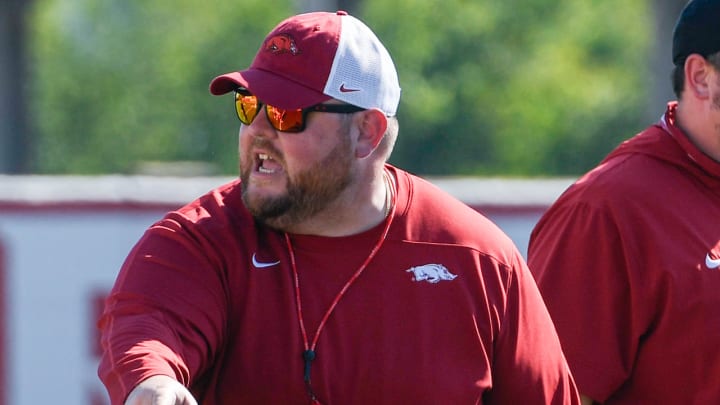 Arkansas Razorbacks offensive line coach Eric Mateos at practice working against the defensive line.