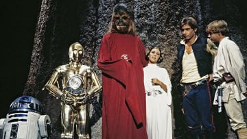 (L to r) R2-D2, Anthony Daniels as C-3PO, Peter Mayhew as Chewbacca, Carrie Fisher as Princess Leia, Harrison Ford as Han Solo, and Mark Hamill as Luke Skywalker in the Star Wars Holiday Special