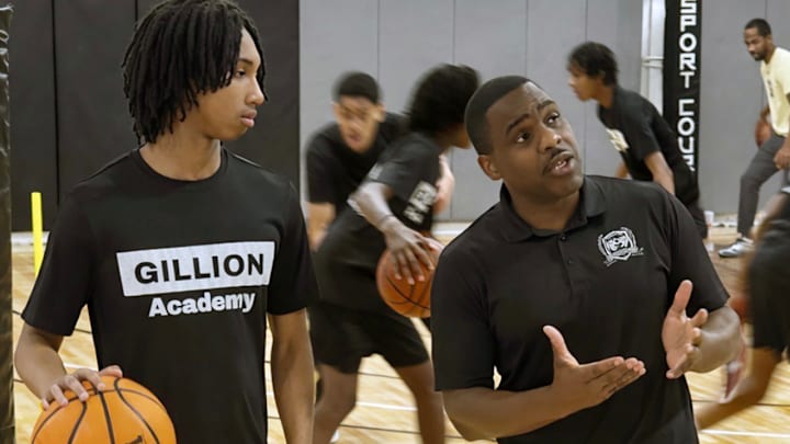 Gillion Academy founder and head basketball coach Kenny Gillion (right) makes a point to star sophomore guard Aaron Bryant during a recent practice.