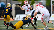 Mater Dei quarterback Ryan Hopkins leans into a passing lane during his team's win over St. Thomas Aquinas at the 2025 Broward County National Football Showcase.; The Monarchs open in big game at Orange Lutheran as Trinity League gets underway.