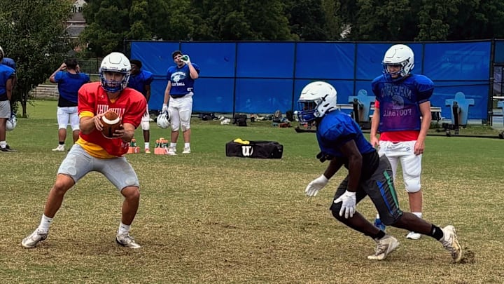 Winston Churchill football players work on the handoff exchange during a 2025 training camp practice.