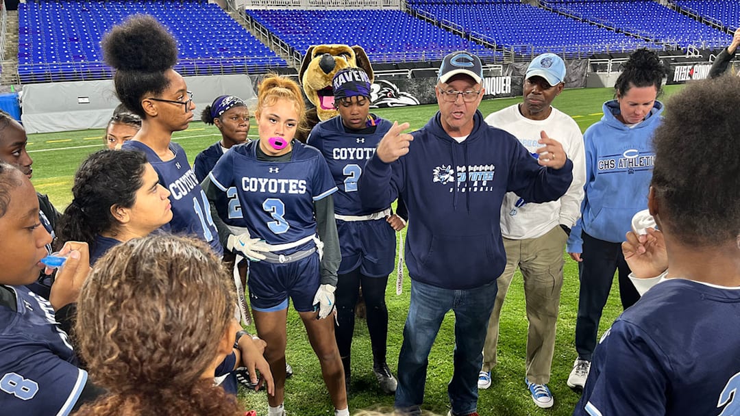 Clarksburg girls flag football head coach K.C. Landefeld speaks with his team during halftime of Friday's state championship game at M&T Bank Stadium.