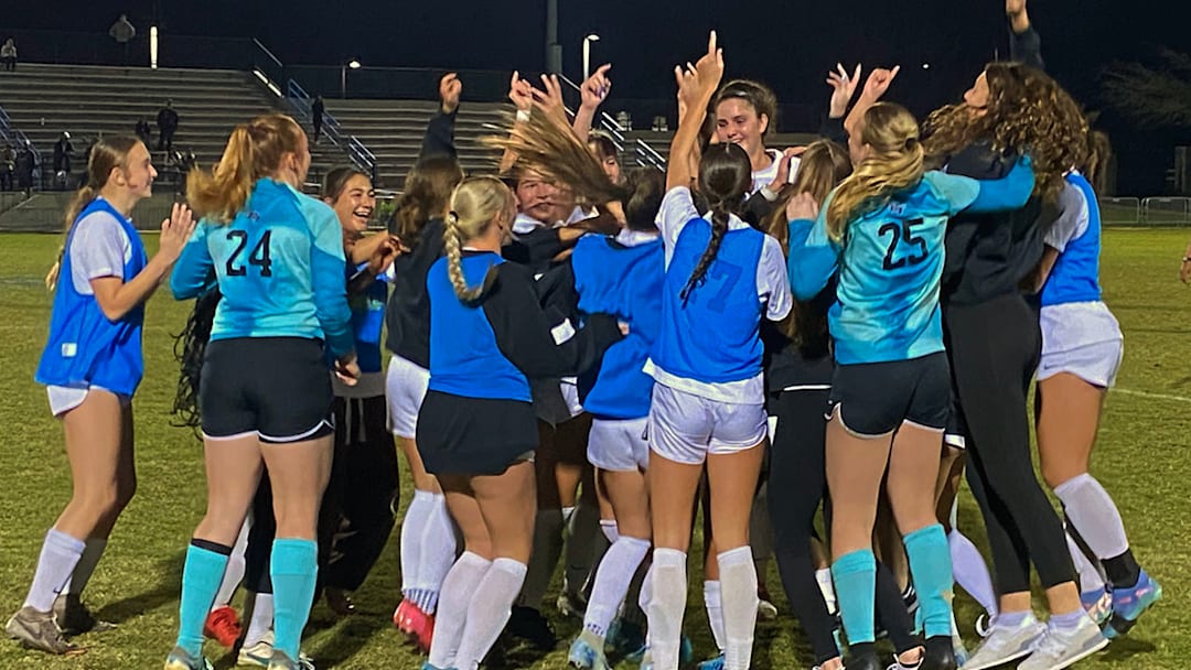 Bartram Trail players mob Ali Fletcher and celebrate winning the FHSAA Class 6A girls state soccer championship on Fletcher's header with 19 seconds remaining in a second overtime session on Saturday at Lake Myrtle Sports Complex.