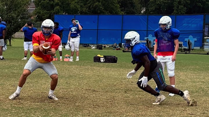 Winston Churchill football players work on the handoff exchange during a 2025 training camp practice.