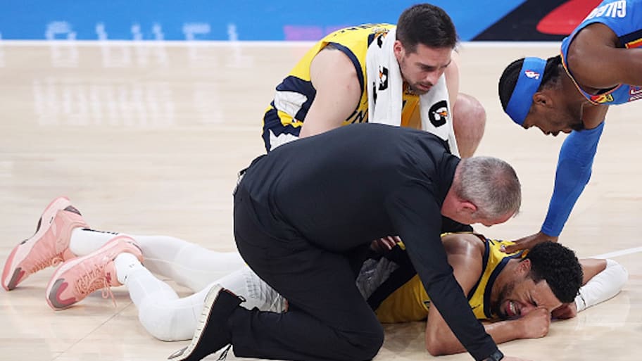 T.J. McConnell and Shai Gilgeous-Alexander try to comfort Tyrese Haliburton. | Photo by Justin Ford / Getty Images