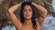 Salma Hayek Pinault was photographed by Ruven Afanador in Mexico. Swimsuit by Alameda Turquesa. Body chain by Baby Gold. Cuff by JUJU VERA.