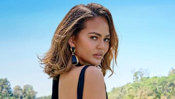 Chrissy Teigen was photographed by Yu Tsai in Los Angeles. Swimsuit by Mugler. Vintage earrings: Essex.