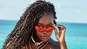 Achieng Agutu was photographed by Ben Watts in Bermuda. Suit by JMP The Label. Necklaces by Spicy Dan. Sunglasses by Le Specs.