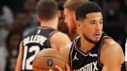 Nov 21, 2025; Phoenix, Arizona, USA; Phoenix Suns guard Devin Booker (left) controls the ball as forward Royce O'Neale (right) defends against the Minnesota Timberwolves forward Jaden McDaniels in the first half of an NBA Cup game at Mortgage Matchup Center. Mandatory Credit: Mark J. Rebilas-Imagn Images
