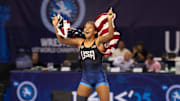 Draped in the American flag, Taina Fernandez celebrates on the mat after her Gold Medal victory at the 2025 U17 World Championships.