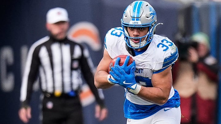 Detroit Lions running back Sione Vaki (33) runs against Chicago Bears linebacker Amen Ogbongbemiga (45) and defensive end Jacob Martin (55) during the second half at Soldier Field in Chicago, Ill. on Sunday, Dec. 22, 2024.
