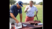 DeChambeau and Evans get to work on some golf balls.