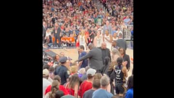 An Indiana Fever fan is escorted out of TD Garden by security in Tuesday's game between the Fever and the Connecticut Sun.