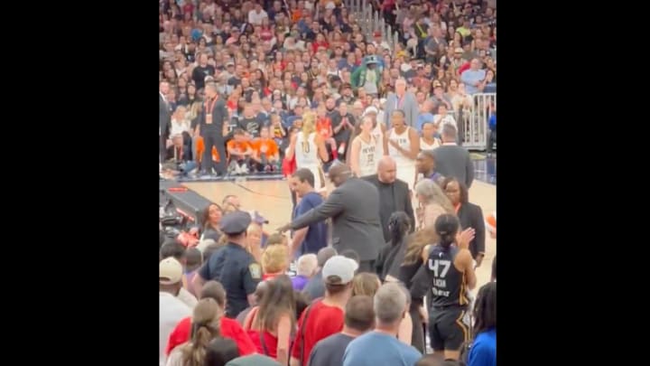 An Indiana Fever fan is escorted out of TD Garden by security in Tuesday's game between the Fever and the Connecticut Sun.