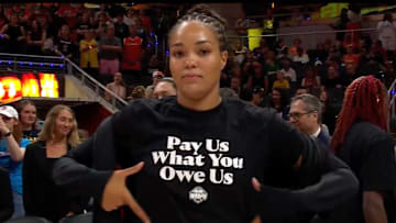 Minnesota Lynx star Napheesa Collier highlights her pregame All-Star game shirt that reads, "Pay Us What You Owe Us." The WNBA players' union is currently negotiating a new Collective Bargaining Agreement (CBA) with the league.