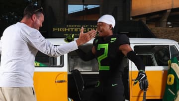 Four-star wide receiver recruit Isaiah Mozee dresses in an Oregon uniform next to coach Dan Lanning during a visit to Eugene.