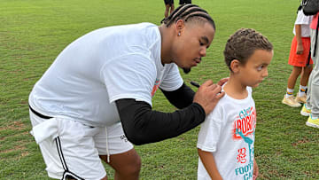Current Miami Dolphin Chop Robinson, a Quince Orchard grad, signs the t-shirt of a young fan at his recent youth camp in Gaithersburg, Maryland.