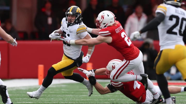 Nov 24, 2023; Lincoln, Nebraska, USA; Iowa Hawkeyes wide receiver Kaden Wetjen (21) is tackled by Nebraska Cornhuskers defensive back Isaac Gifford (2) at Memorial Stadium. Mandatory Credit: Reese Strickland-USA TODAY Sports