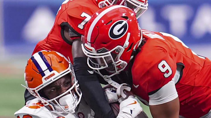 Aug 31, 2024; Atlanta, Georgia, USA; Georgia Bulldogs defensive back Daniel Harris (7) and defensive back Justyn Rhett (9) tackle Clemson Tigers wide receiver Bryant Wesco Jr. (12) during the second half at Mercedes-Benz Stadium.