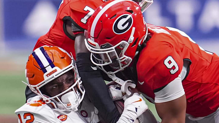 Aug 31, 2024; Atlanta, Georgia, USA; Georgia Bulldogs defensive back Daniel Harris (7) and defensive back Justyn Rhett (9) tackle Clemson Tigers wide receiver Bryant Wesco Jr. (12) during the second half at Mercedes-Benz Stadium. Mandatory Credit: Dale Zanine-Imagn Images