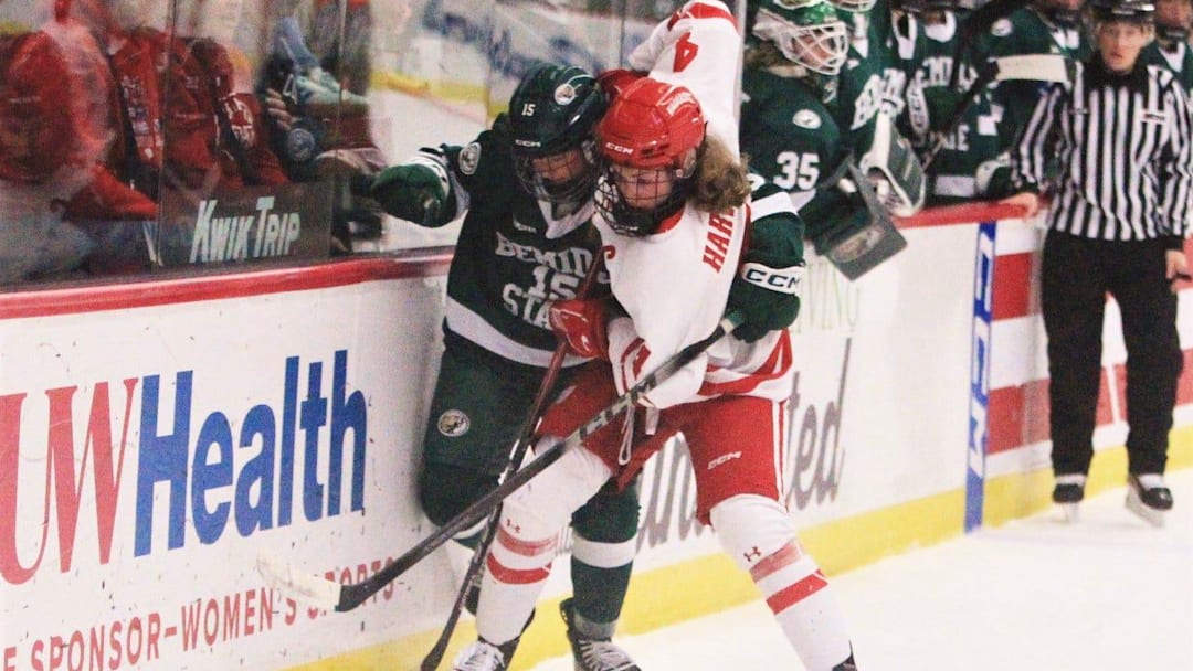 Wisconsin's Caroline Harvey (4) and Bemidji State's Shelby Sandberg fight for the puck during the first period of the Badgers' 3-2 overtime victory Saturday Feb. 28, 2026 at LaBahn Arena in Madison, Wisconsin.