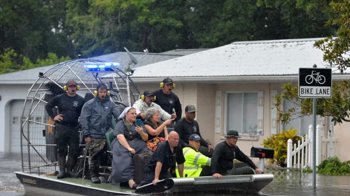 An airboat carrying evacuees from the Pinecraft neighborhood of Sarasota approaches dry land Aug. 5. Multiple law enforcement and rescue agencies conducted evacuations in the area following Tropical Storm Debby