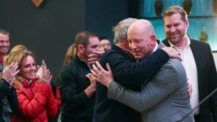 Louisville football coach Jeff Brohm embraces Dennis Lampley after Brohm was introduced as the Cardinals' head coach.