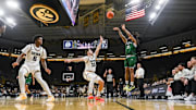Chicago State Cougars guard Braelon Bush (21) shoots over Iowa Hawkeyes guard Brendan Hausen (15) and guard Tavion Banks (6)