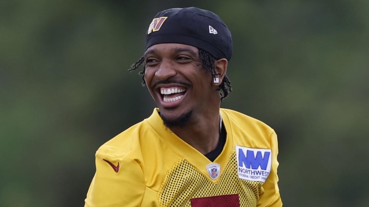 Jul 26, 2024; Ashburn, VA, USA; Washington Commanders quarterback Jayden Daniels (5) jokes during warmup before day three of training camp at Commanders Park. Mandatory Credit: Geoff Burke-USA TODAY Sports