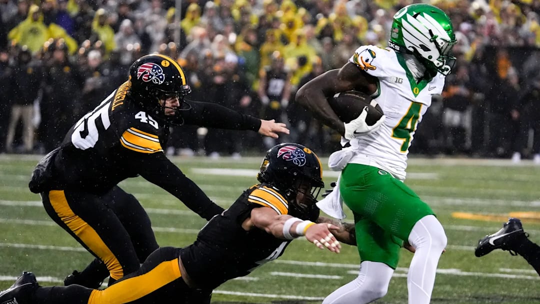 Iowa Hawkeyes defensive back Koen Entringer (4) tries to tackle Oregon Ducks wide receiver Malik Benson (4)