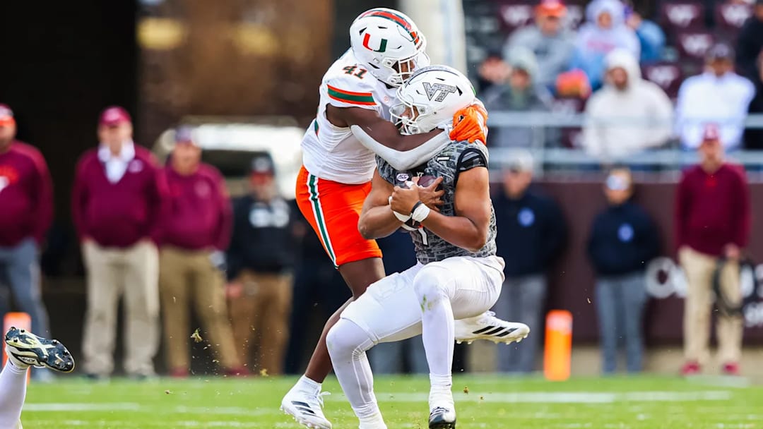 Nov 22, 2025; Blacksburg, Virginia, USA; Virginia Tech Hokies quarterback Kyron Drones (1) sacked by Miami Hurricanes Chase Smith (41) during the second quarter at Lane Stadium. 