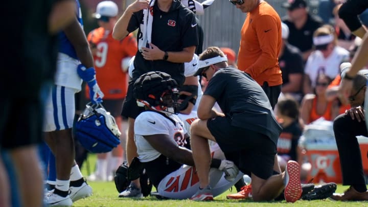 Cincinnati Bengals defensive end Myles Murphy (99) is assisted by the training staff after going down with an injury during a preseason joint practice at the Paycor Stadium practice facility in downtown Cincinnati on Tuesday, Aug. 20, 2024.