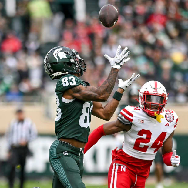 Michigan State's Montorie Foster Jr., left, catches a pass as Nebraska's Marques Buford Jr. defends