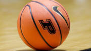 A NCAA women's basketball with the Purdue University logo sits on the court